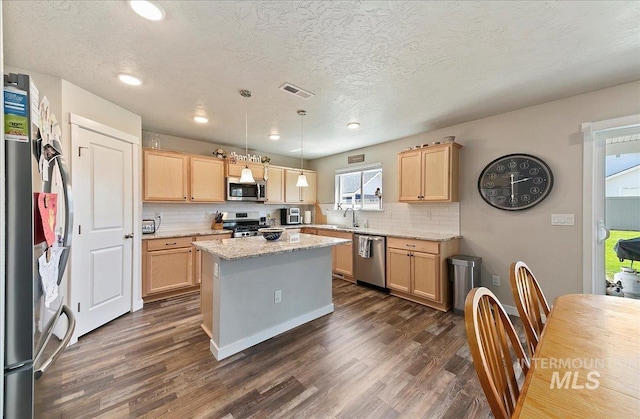 11299 W Taviton St, Nampa, ID 83651 - kitchen with stainless steel appliances, light brown cabinets, dark wood-type flooring, a sink, and a textured ceiling