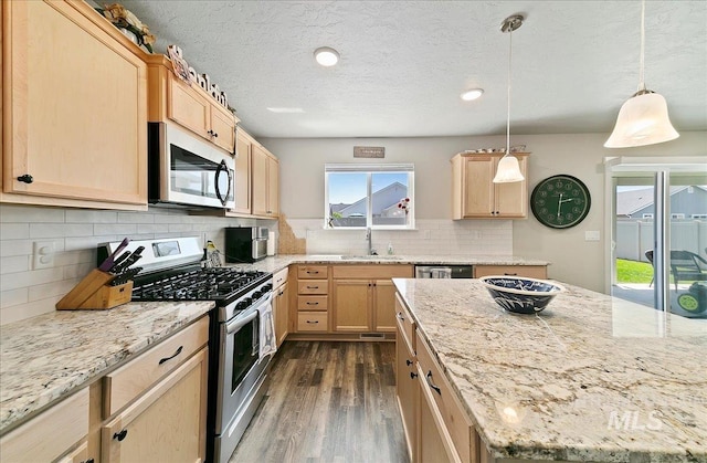 11299 W Taviton St, Nampa, ID 83651 - kitchen with appliances with stainless steel finishes, light brown cabinets, dark wood-style floors, backsplash, and a textured ceiling