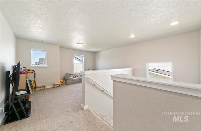 11299 W Taviton St, Nampa, ID 83651 - hall with an upstairs landing, light carpet, a textured ceiling, baseboards, and recessed lighting