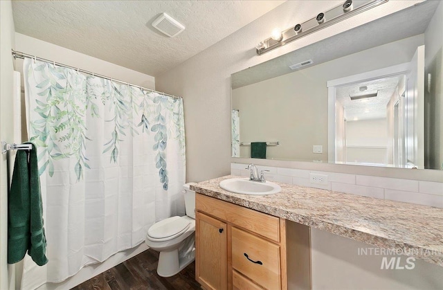 11299 W Taviton St, Nampa, ID 83651 - full bath featuring toilet, vanity, wood finished floors, and a textured ceiling