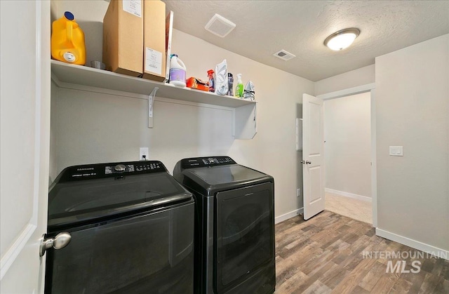 11299 W Taviton St, Nampa, ID 83651 - washroom featuring separate washer and dryer, wood finished floors, baseboards, and a textured ceiling