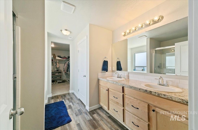 11299 W Taviton St, Nampa, ID 83651 - full bath featuring a stall shower, wood finished floors, double vanity, a spacious closet, and baseboards