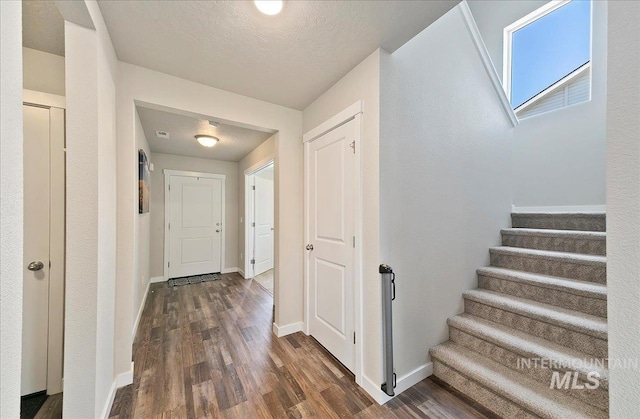 11299 W Taviton St, Nampa, ID 83651 - foyer featuring dark wood-type flooring, stairway, baseboards, and a textured ceiling