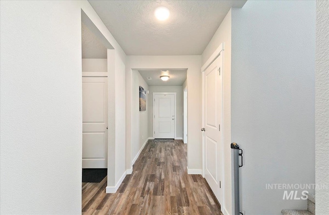 11299 W Taviton St, Nampa, ID 83651 - hall with dark wood-style floors, baseboards, and a textured ceiling