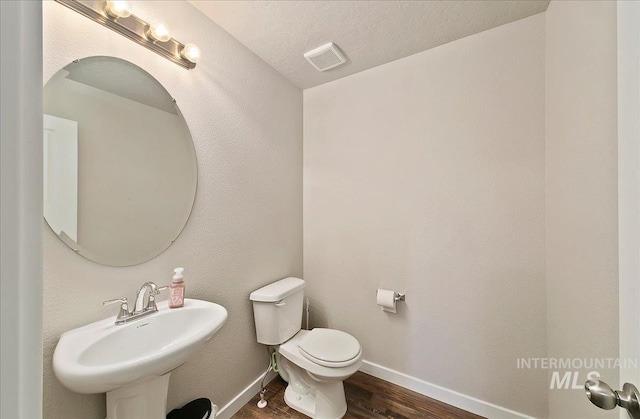 11299 W Taviton St, Nampa, ID 83651 - bathroom featuring wood finished floors, toilet, a sink, and baseboards