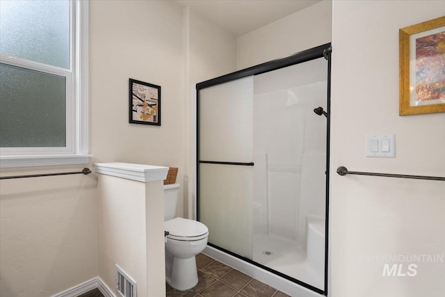 bathroom with an enclosed shower, toilet, and tile patterned floors