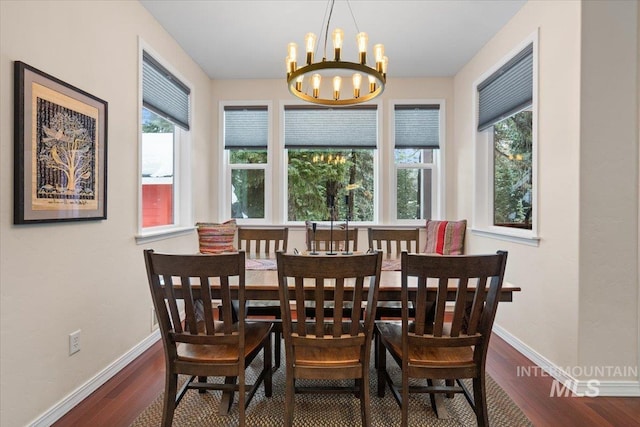 dining room with dark hardwood / wood-style floors and a notable chandelier