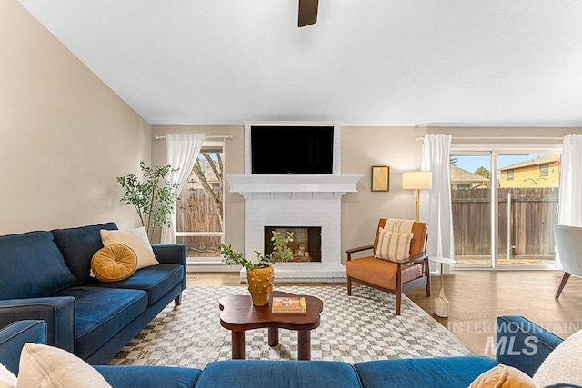 living area with light wood-type flooring and a brick fireplace