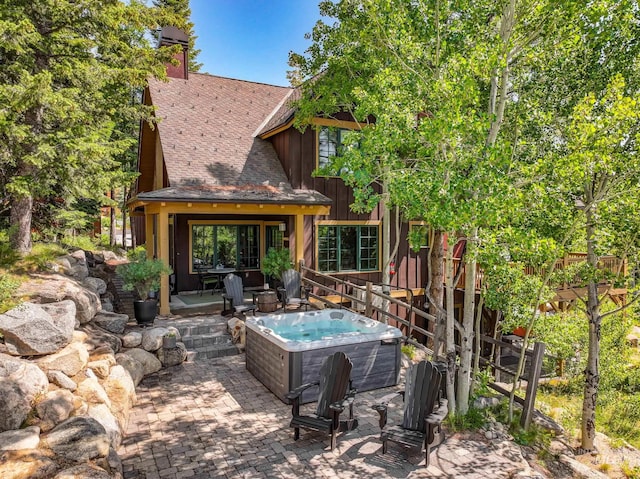 7 Golden Bench Ct, Donnelly, ID 83615 - back of property featuring a hot tub, roof with shingles, a patio area, and board and batten siding
