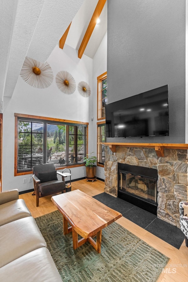 7 Golden Bench Ct, Donnelly, ID 83615 - living room with high vaulted ceiling, a stone fireplace, healthy amount of natural light, wood finished floors, and beam ceiling