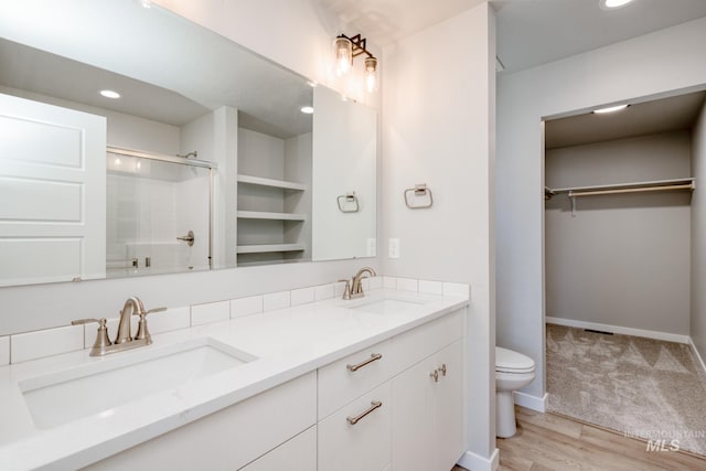 3530 W Littleton Dr, Meridian, ID 83642 - bathroom featuring double vanity, an enclosed shower, a walk in closet, wood finished floors, and recessed lighting