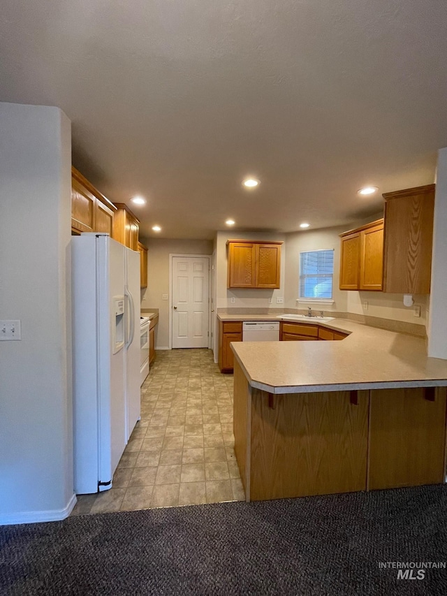 kitchen with light carpet, white appliances, and kitchen peninsula