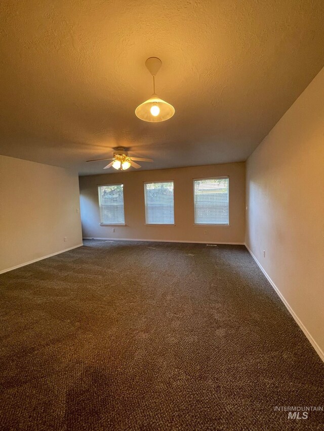 spare room with a textured ceiling, carpet flooring, a healthy amount of sunlight, and ceiling fan