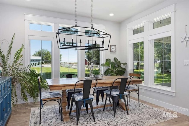 dining room with light hardwood / wood-style floors and a notable chandelier