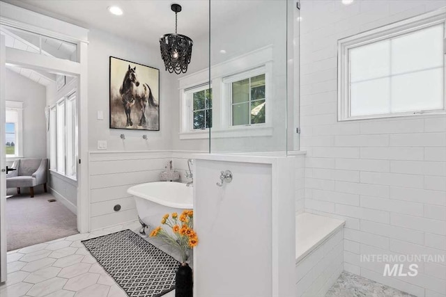 bathroom with tile patterned flooring, vaulted ceiling, and plenty of natural light