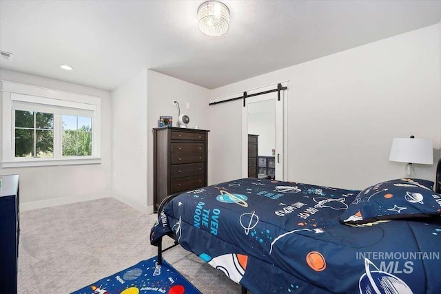 bedroom featuring a barn door and carpet