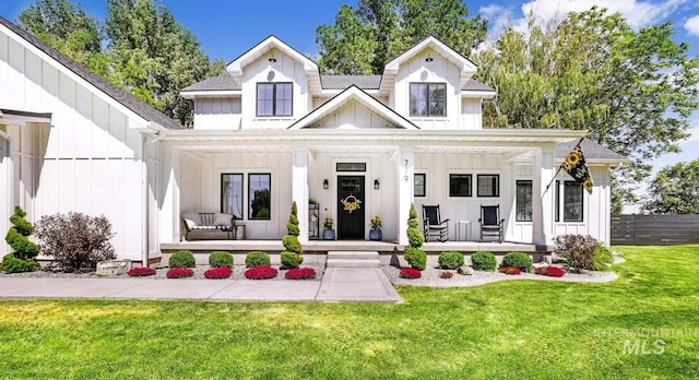 modern farmhouse with a front lawn and covered porch