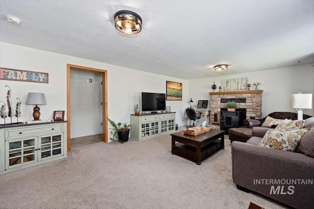 living room with a wood stove, light carpet, and a textured ceiling