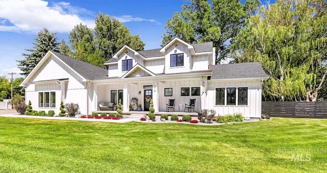 back of property featuring covered porch and a lawn