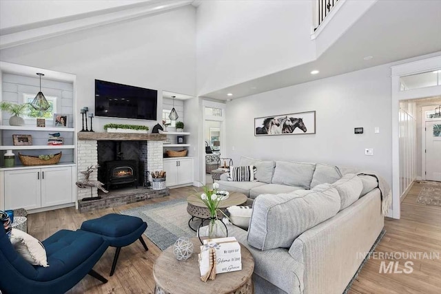 living room featuring beamed ceiling, high vaulted ceiling, and light wood-type flooring