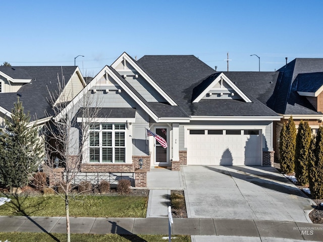 craftsman-style home with concrete driveway, brick siding, and an attached garage