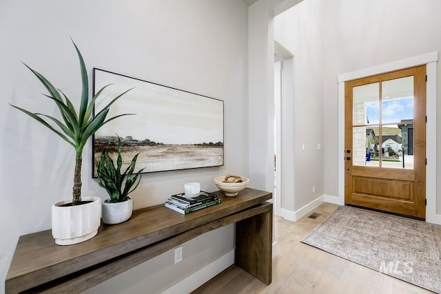 entryway featuring baseboards and light wood finished floors
