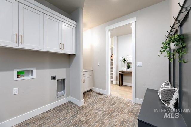 laundry area with baseboards, washer hookup, cabinet space, and hookup for an electric dryer
