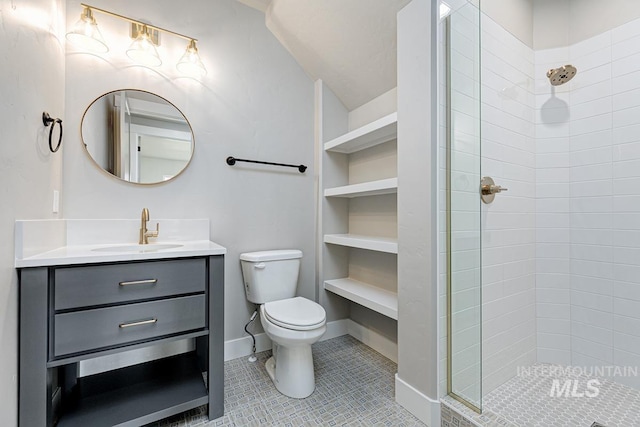 bathroom with tile patterned flooring, vanity, toilet, baseboards, and tiled shower