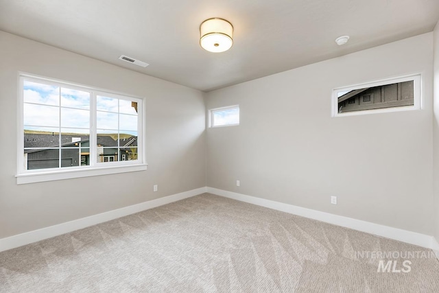 carpeted spare room with baseboards and visible vents