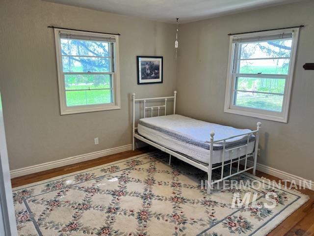 bedroom featuring wood finished floors and baseboards