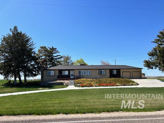 single story home with a garage, driveway, and a front lawn