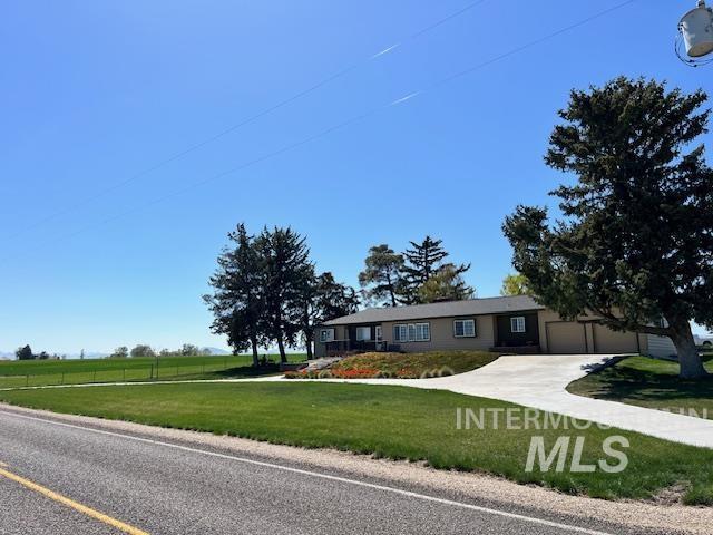 single story home with a garage and a front lawn