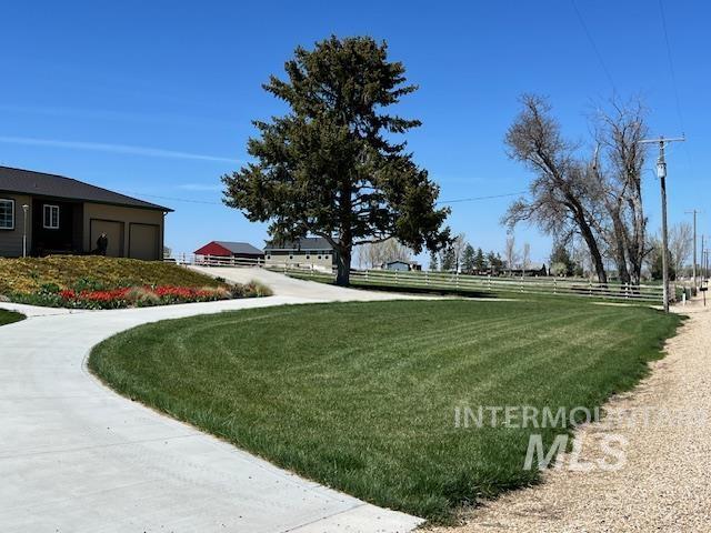 view of community featuring a yard, fence, and a garage