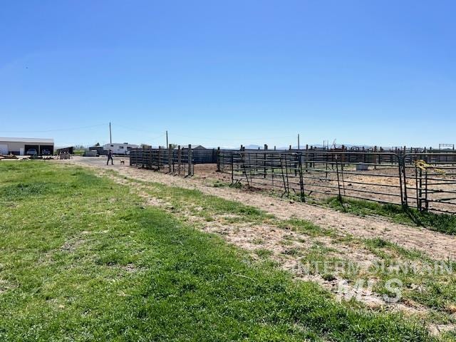 view of yard with fence and a rural view