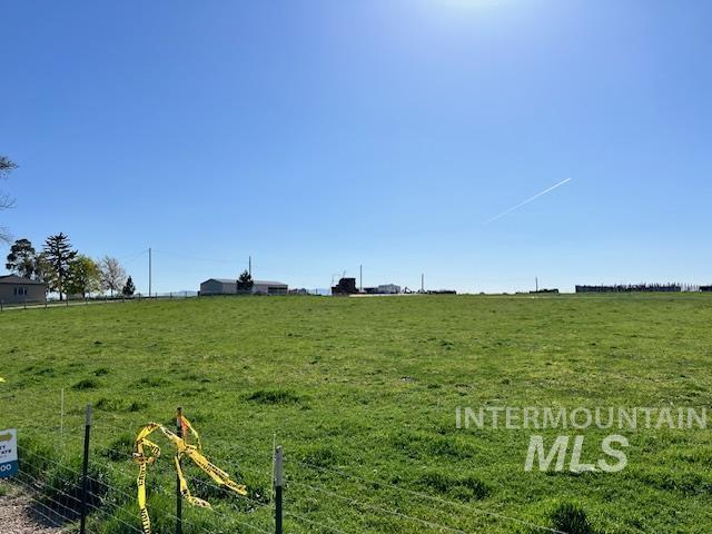 view of yard with a rural view and fence