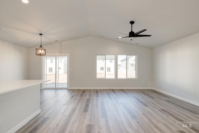 7308 E Marble Springs Dr, Nampa, ID 83687 - unfurnished living room featuring baseboards, light wood-type flooring, ceiling fan with notable chandelier, and lofted ceiling