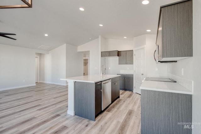 7308 E Marble Springs Dr, Nampa, ID 83687 - kitchen with lofted ceiling, appliances with stainless steel finishes, light countertops, open floor plan, and light wood-type flooring