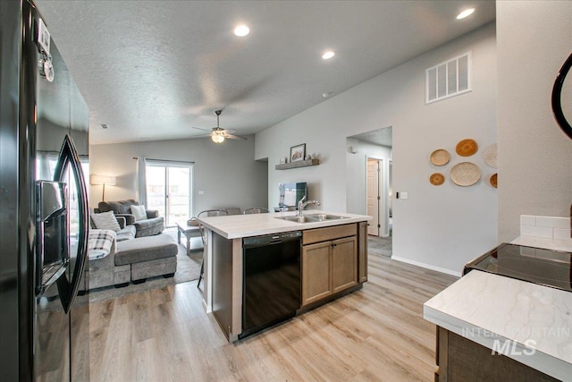 kitchen featuring visible vents, refrigerator with ice dispenser, a sink, black dishwasher, and open floor plan