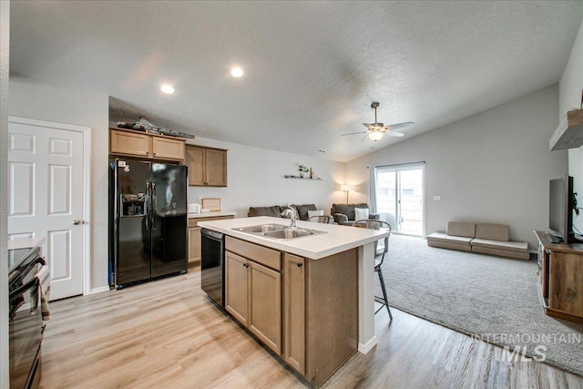 kitchen with lofted ceiling, ceiling fan, a sink, black appliances, and open floor plan