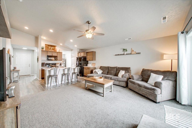 living area with visible vents, lofted ceiling, recessed lighting, a textured ceiling, and a ceiling fan