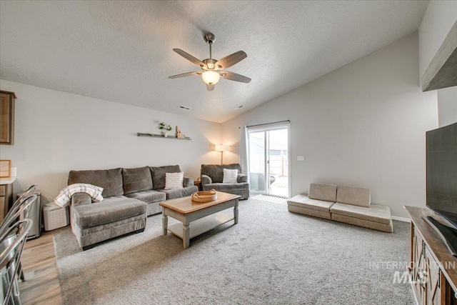 living room with visible vents, a ceiling fan, a textured ceiling, light wood-style floors, and lofted ceiling