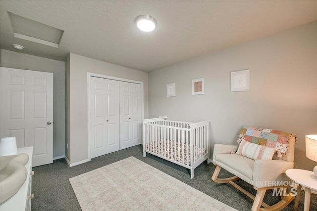 bedroom featuring dark colored carpet, a closet, baseboards, and attic access