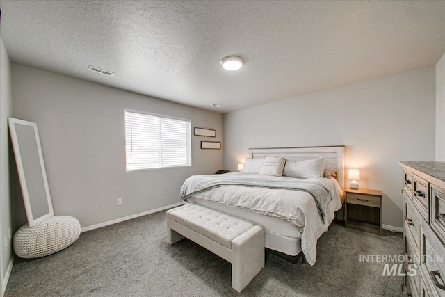 bedroom featuring a textured ceiling, visible vents, dark colored carpet, and baseboards