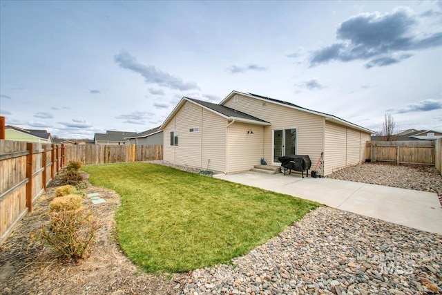 back of property with a fenced backyard, entry steps, a patio, and a yard