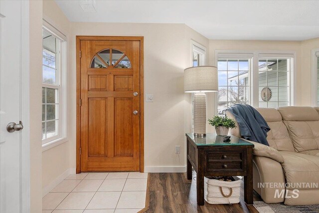 foyer with light wood-style floors and baseboards