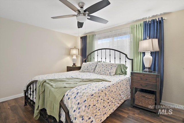 bedroom featuring dark wood finished floors, a ceiling fan, and baseboards