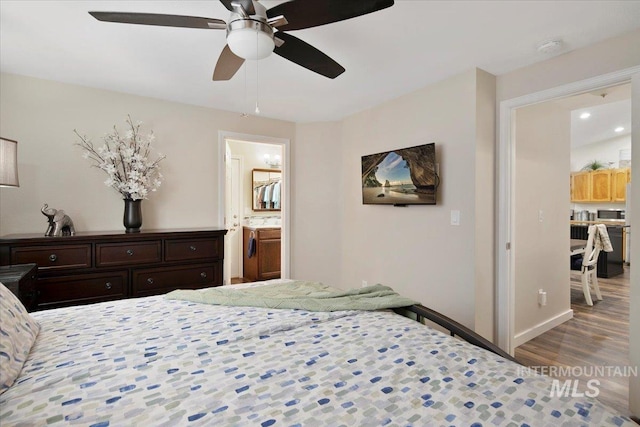 bedroom with ceiling fan, baseboards, wood finished floors, and connected bathroom