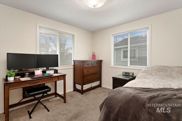 bedroom with light carpet and baseboards