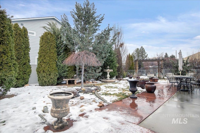 snow covered patio with fence and a pergola