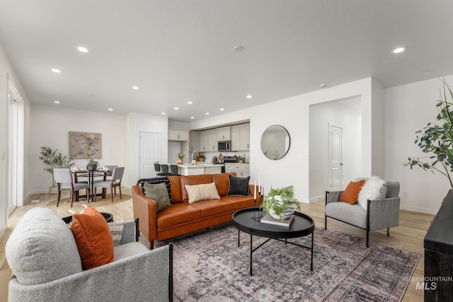 living room with sink and light hardwood / wood-style floors